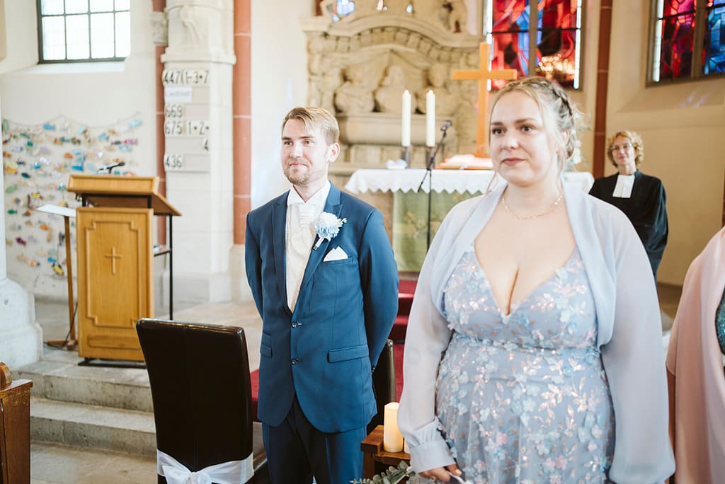 Bräutgam und Trauzeugin vor dem Altar.