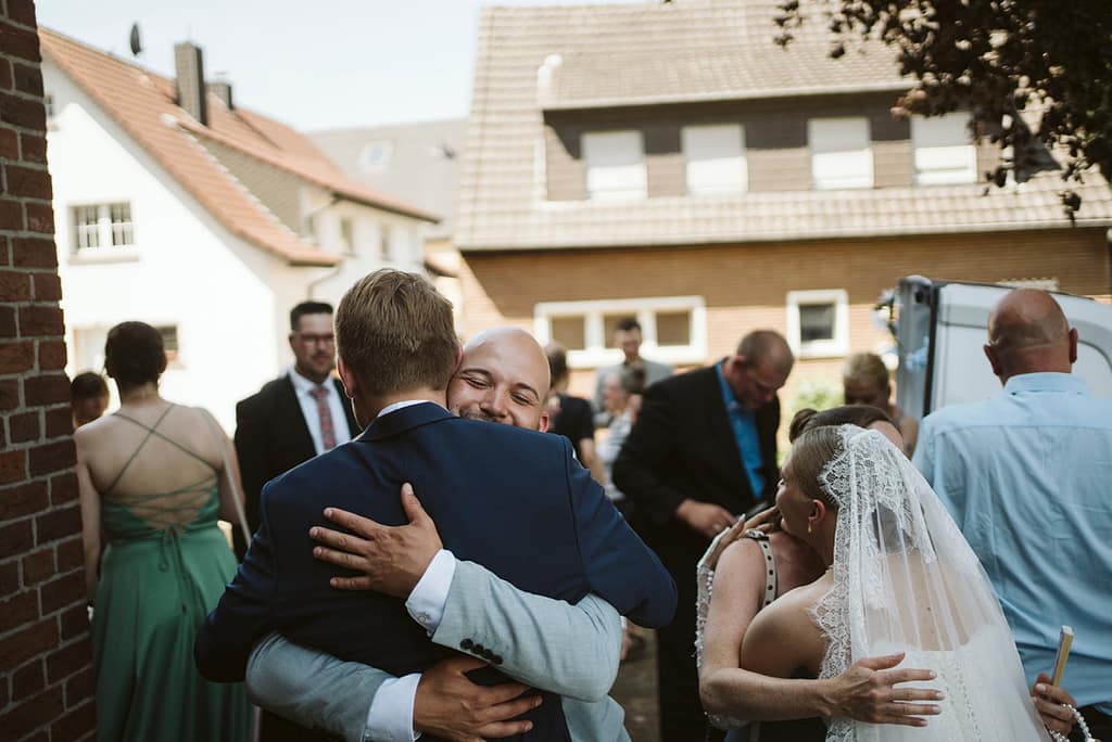 Ein Gast umarmt den Bräutigam herzlich und sichtbar glücklich.