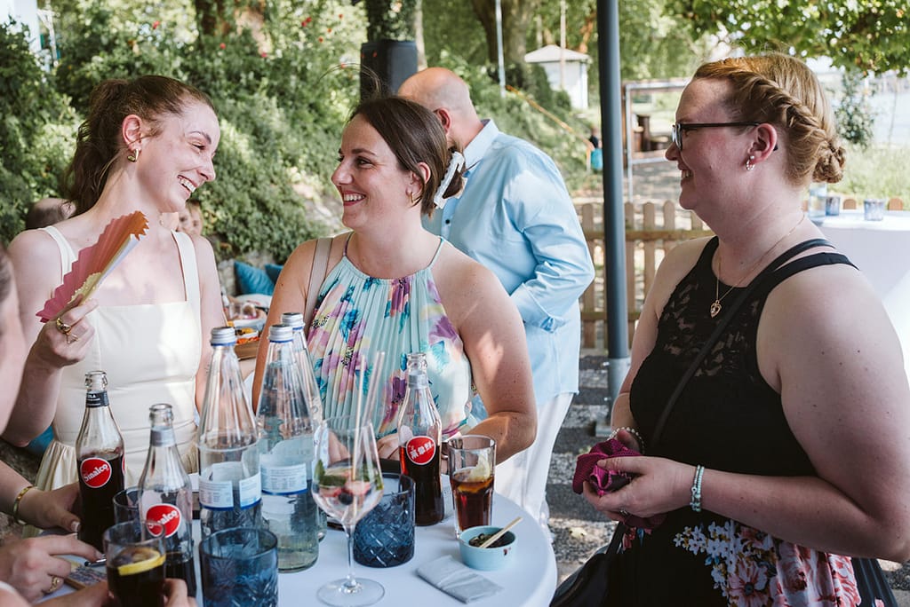 Frauen, die an einem Tisch in Unterhaltung versunken sind und lachen.