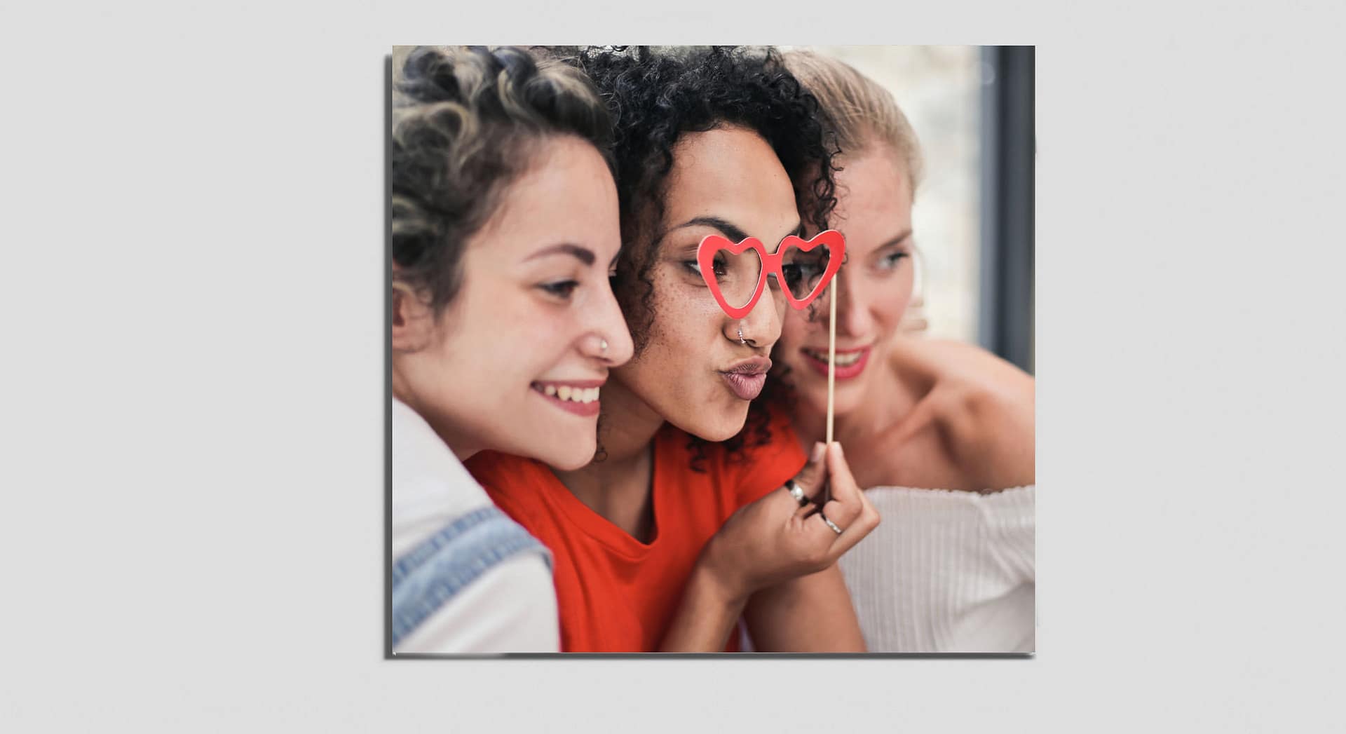 Bild auf dem Gutschein für ein Friends-Fotoshooting mit drei Freundinnen und einer roten Herzbrille.