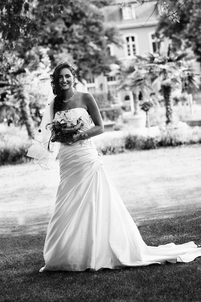 Braut Sabrina im Hochzeitskleid mit Brautstrauß, fotografiert in Schwarzweiß